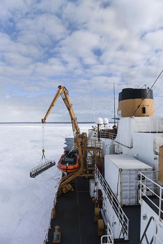 Ein KranfÃ¼hrer senkt die Gangway der Polar Star auf das Eis im McMurdo Sound. Nachdem geeigneten Eis gefunden wurde, konnten Passagier und Crew des Eisbrechers auf dem Eis an Land gehen. (Bild: U.S. Coast Guard)